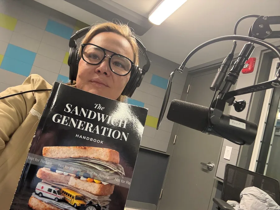 Dr. Irina Koyfman holding The Sandwich Generation Handbook in the recording studio